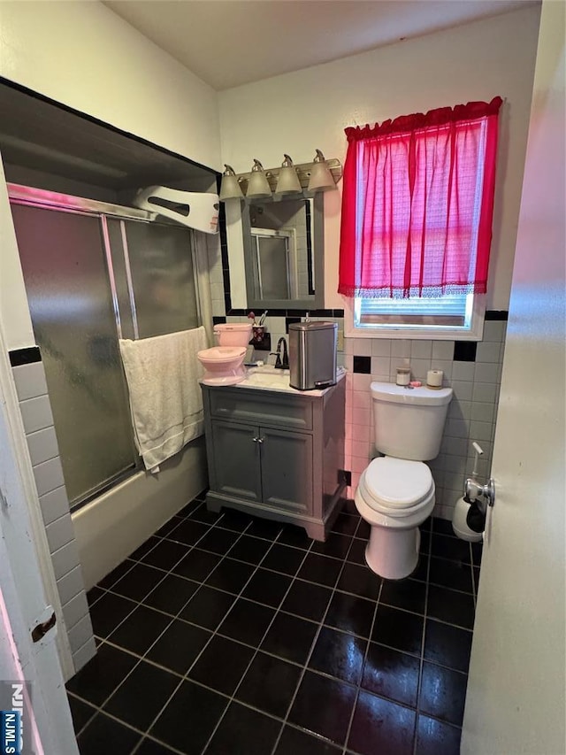 bathroom with tile patterned flooring, toilet, vanity, and tile walls