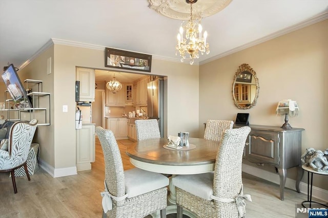 dining room featuring light wood-style floors, a chandelier, and crown molding