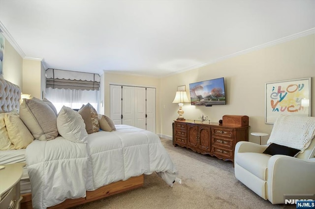 carpeted bedroom with a closet, baseboards, and ornamental molding