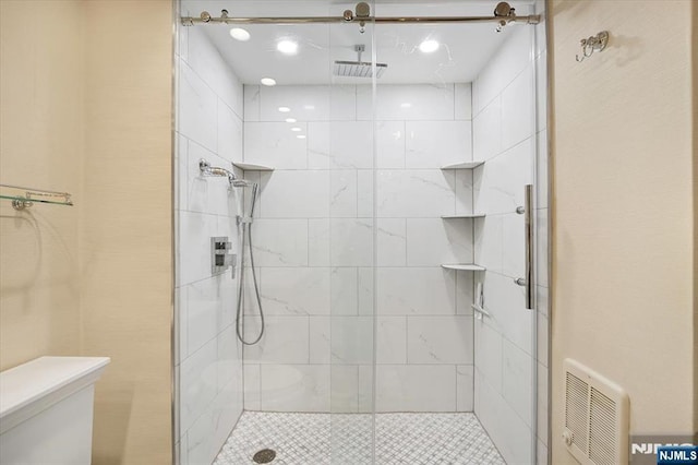 full bathroom with a shower stall, toilet, and visible vents