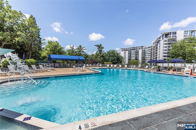 pool with a patio area and fence