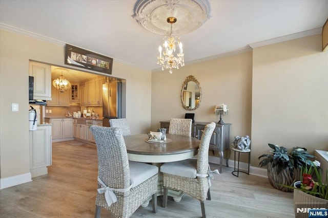 dining room featuring baseboards, light wood finished floors, a chandelier, and ornamental molding