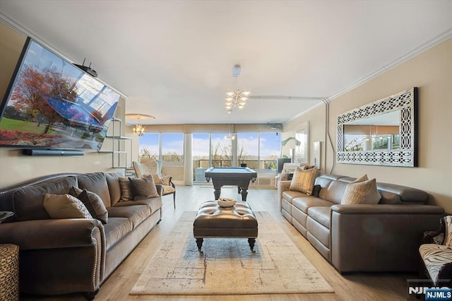 living room with a notable chandelier, crown molding, billiards, and wood finished floors