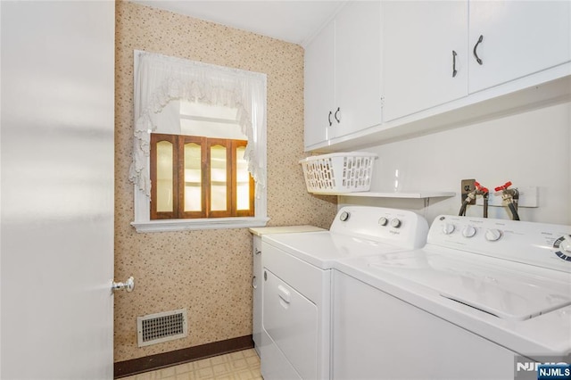 washroom featuring light floors, visible vents, wallpapered walls, cabinet space, and washer and dryer