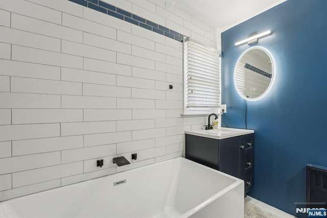 bathroom featuring vanity and a soaking tub