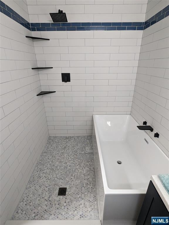 full bathroom featuring a tub, tiled shower, vanity, and tile patterned flooring