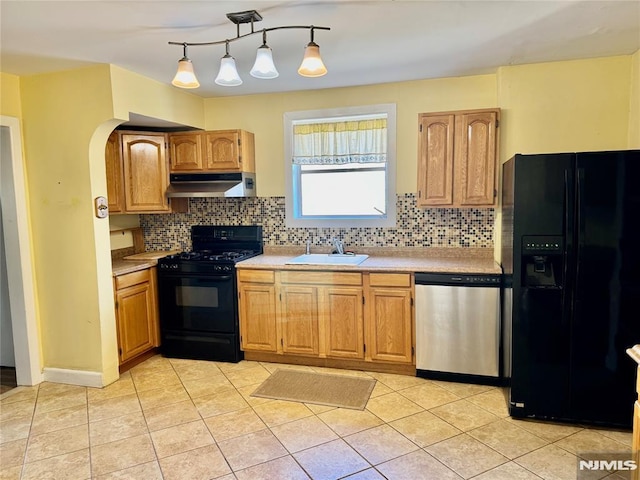 kitchen with under cabinet range hood, black appliances, light countertops, and a sink