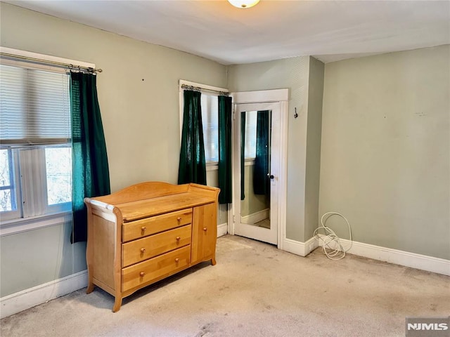 bedroom with baseboards and light carpet