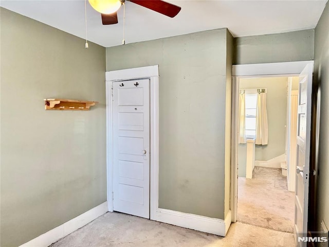 interior space with light carpet and baseboards