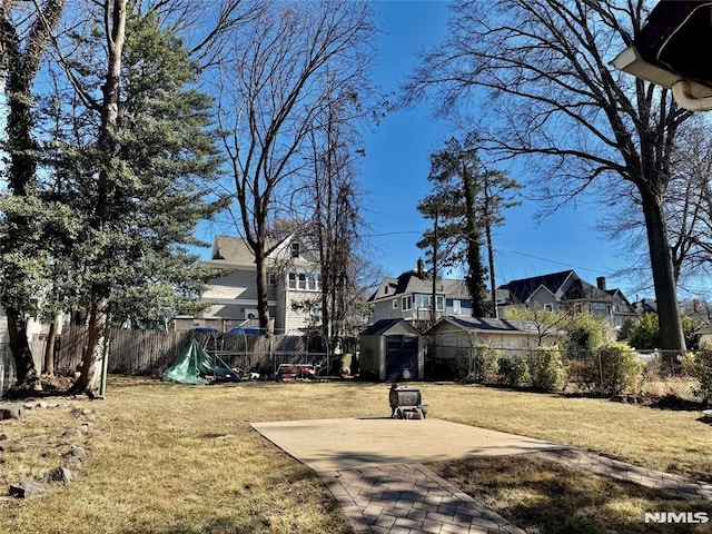 view of yard with a residential view, a fenced backyard, and a patio area