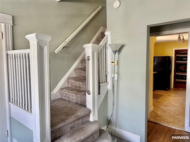 stairs with wood finished floors and baseboards