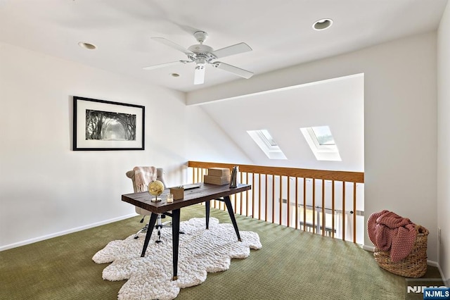 office featuring vaulted ceiling with skylight, baseboards, carpet, and ceiling fan