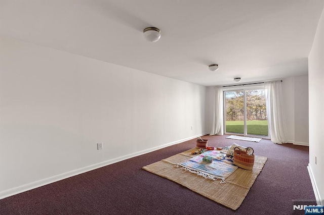 empty room featuring carpet and baseboards