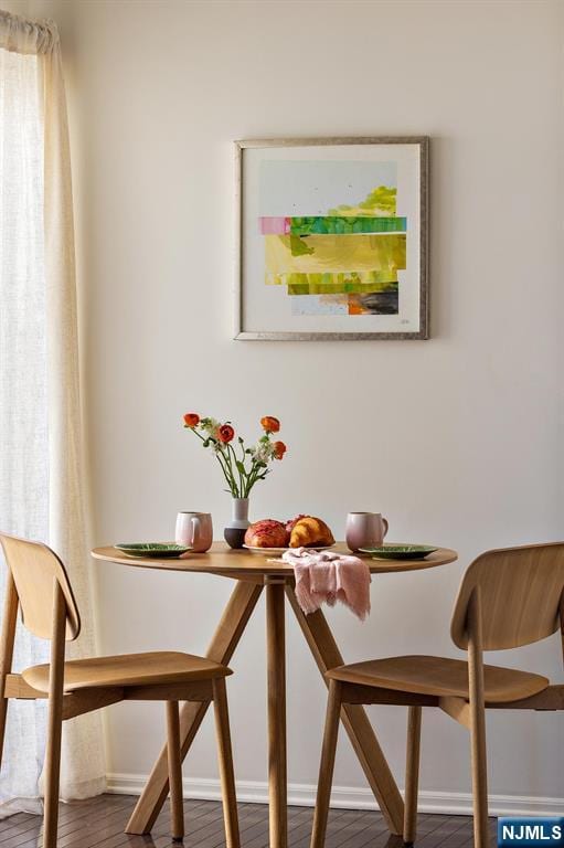 dining space with wood finished floors and baseboards