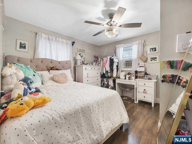 bedroom with dark wood finished floors, multiple windows, and ceiling fan