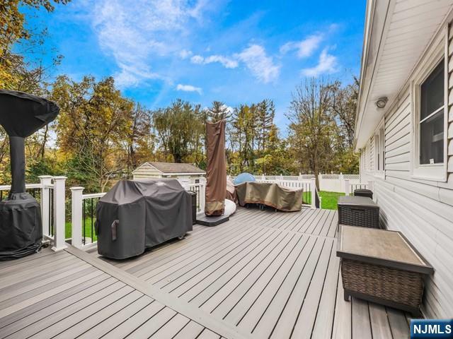 wooden deck featuring a grill and fence