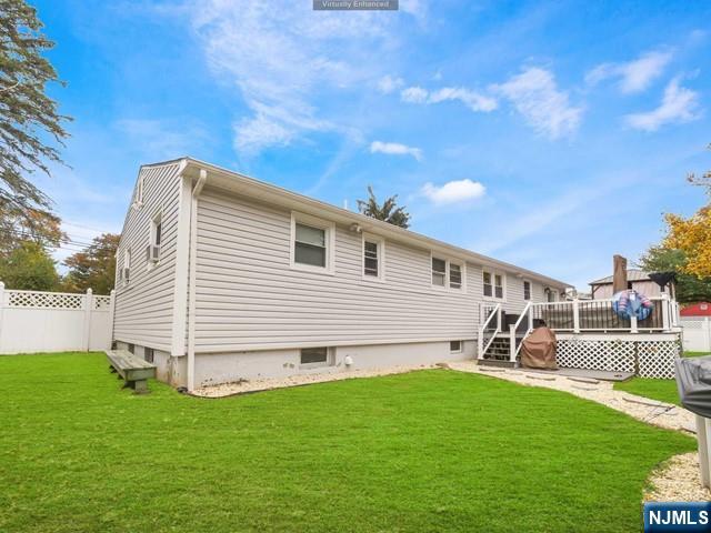 back of house with a yard, a deck, and fence