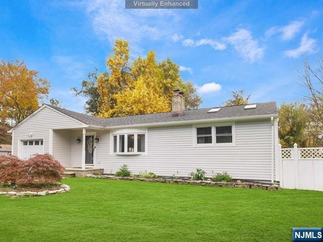 view of front of property featuring a front yard, fence, a garage, and a chimney