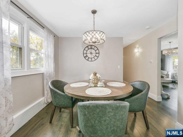 dining space with a notable chandelier, wood finished floors, and baseboards