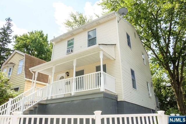 back of property with covered porch and stairs