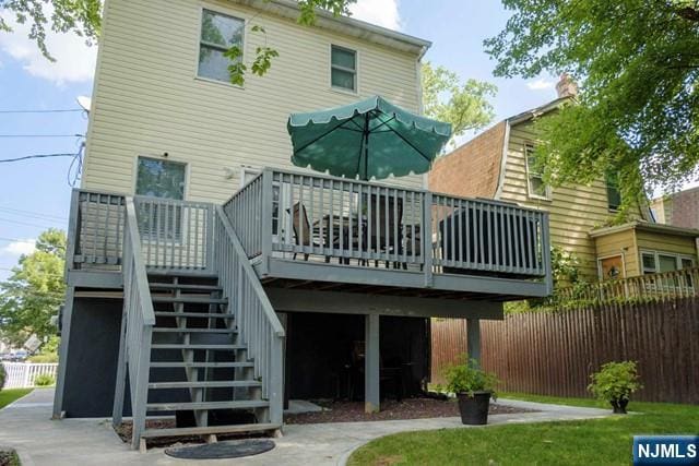 back of house with a deck, stairs, and fence