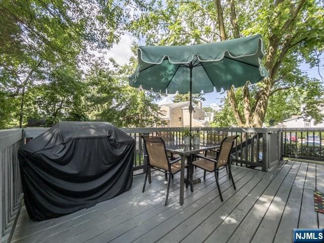 wooden terrace with outdoor dining space and area for grilling