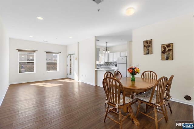 dining room featuring recessed lighting, an inviting chandelier, baseboards, and dark wood-style flooring