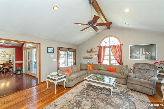 living room featuring plenty of natural light, vaulted ceiling with beams, ceiling fan, and hardwood / wood-style floors