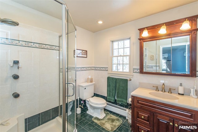 bathroom featuring toilet, tile walls, a shower stall, baseboard heating, and vanity