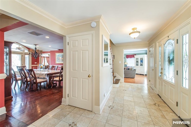 entrance foyer with light tile patterned floors, baseboards, stairs, and crown molding