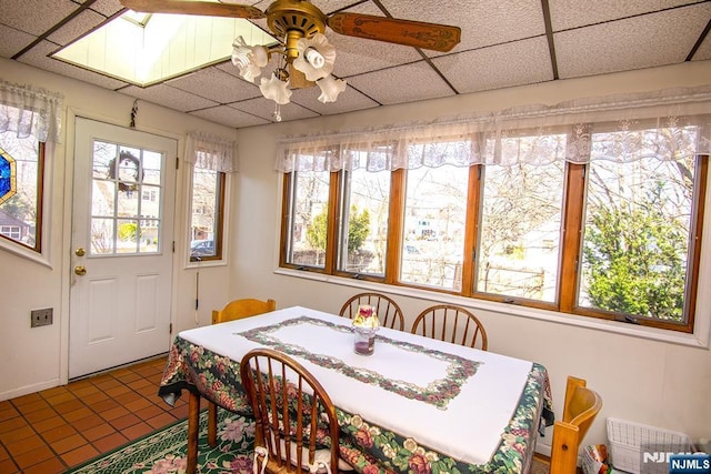 sunroom featuring a ceiling fan and a drop ceiling