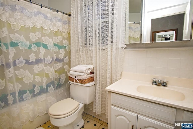 full bathroom with tasteful backsplash, toilet, and vanity