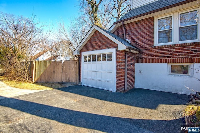 garage with driveway and fence