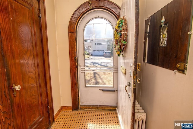 doorway to outside featuring radiator heating unit and baseboards