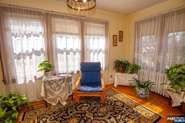 sitting room featuring wood finished floors and ornamental molding