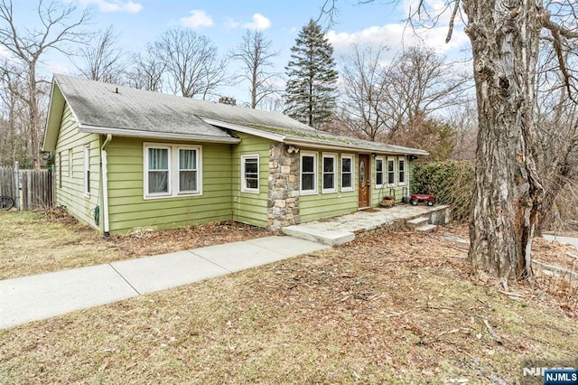 view of front of property with fence and a shingled roof