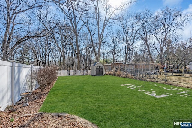 view of yard with an outbuilding, a fenced backyard, and a storage shed