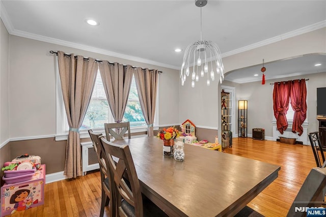 dining space featuring baseboards, ornamental molding, recessed lighting, hardwood / wood-style flooring, and arched walkways