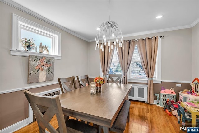 dining room featuring crown molding, a notable chandelier, radiator, and light wood-style flooring