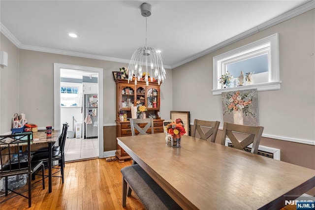 dining area featuring baseboards, ornamental molding, recessed lighting, light wood-style flooring, and a notable chandelier