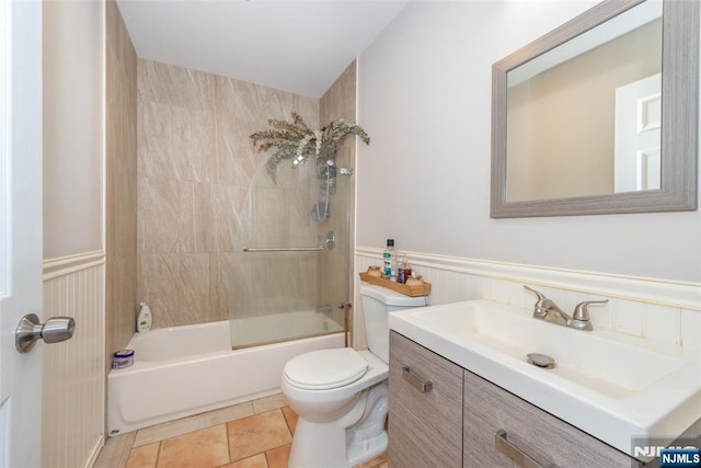 full bathroom with tile patterned flooring, wainscoting, toilet, and shower / tub combination