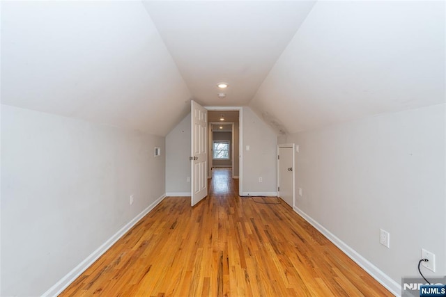 bonus room featuring baseboards, lofted ceiling, and light wood finished floors