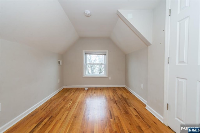 bonus room with lofted ceiling, visible vents, light wood-type flooring, and baseboards