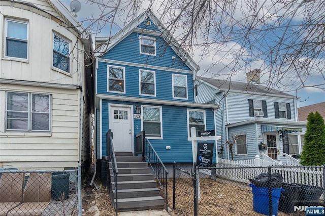 view of front facade with entry steps and a fenced front yard