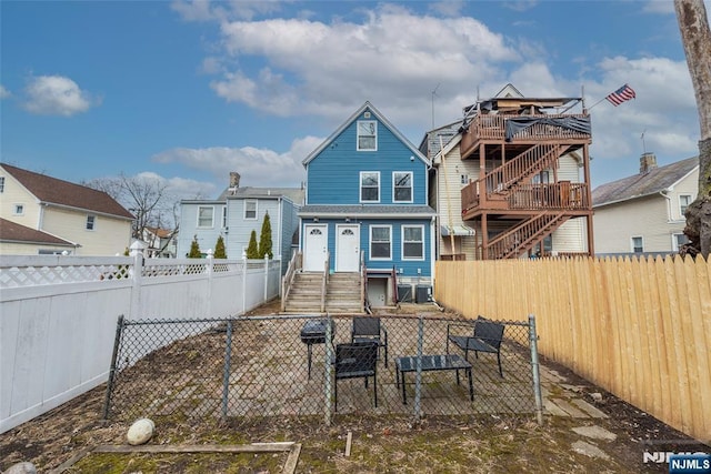 back of house featuring entry steps and a fenced backyard