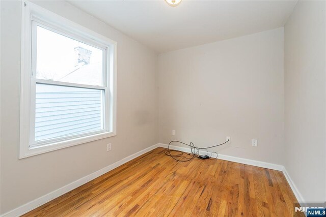 empty room with baseboards and light wood-style flooring