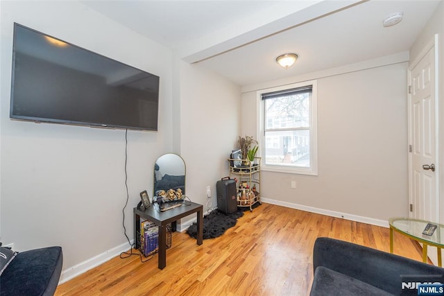 living area featuring light wood finished floors and baseboards