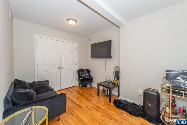 living area with visible vents, baseboards, and light wood finished floors