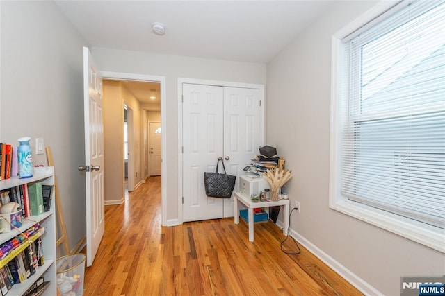 interior space featuring a closet, baseboards, and light wood finished floors