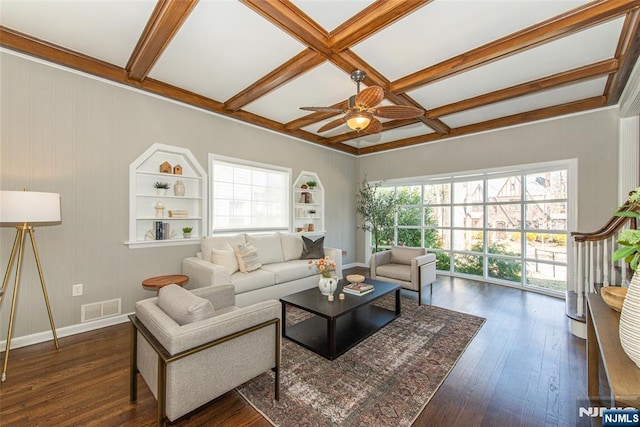 living area with visible vents, hardwood / wood-style floors, beam ceiling, coffered ceiling, and a ceiling fan